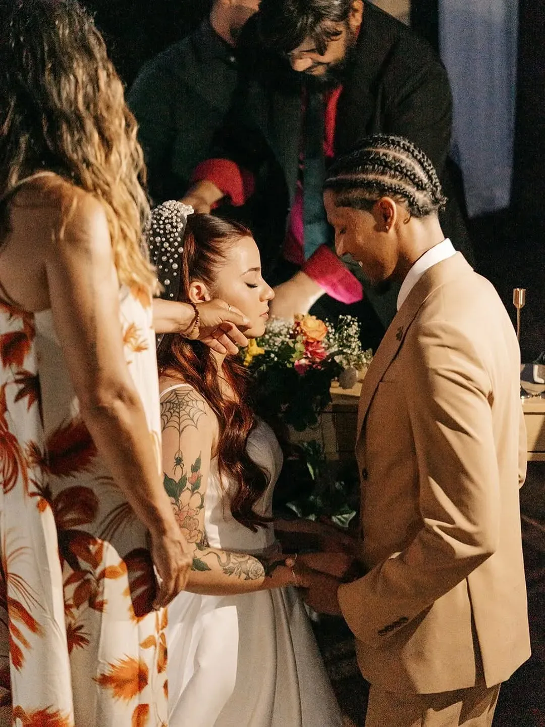 Intimate ceremony ritual with newlyweds holding hands and a tropical flower bouquet