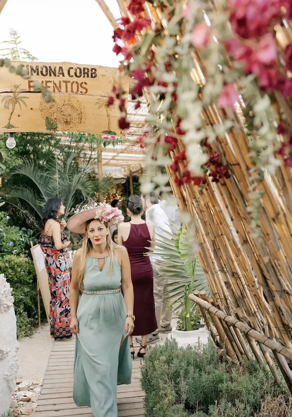 Portal vegetal do Algarve Jungle Events com convidada vestida de verde e chapéu rosa coral
